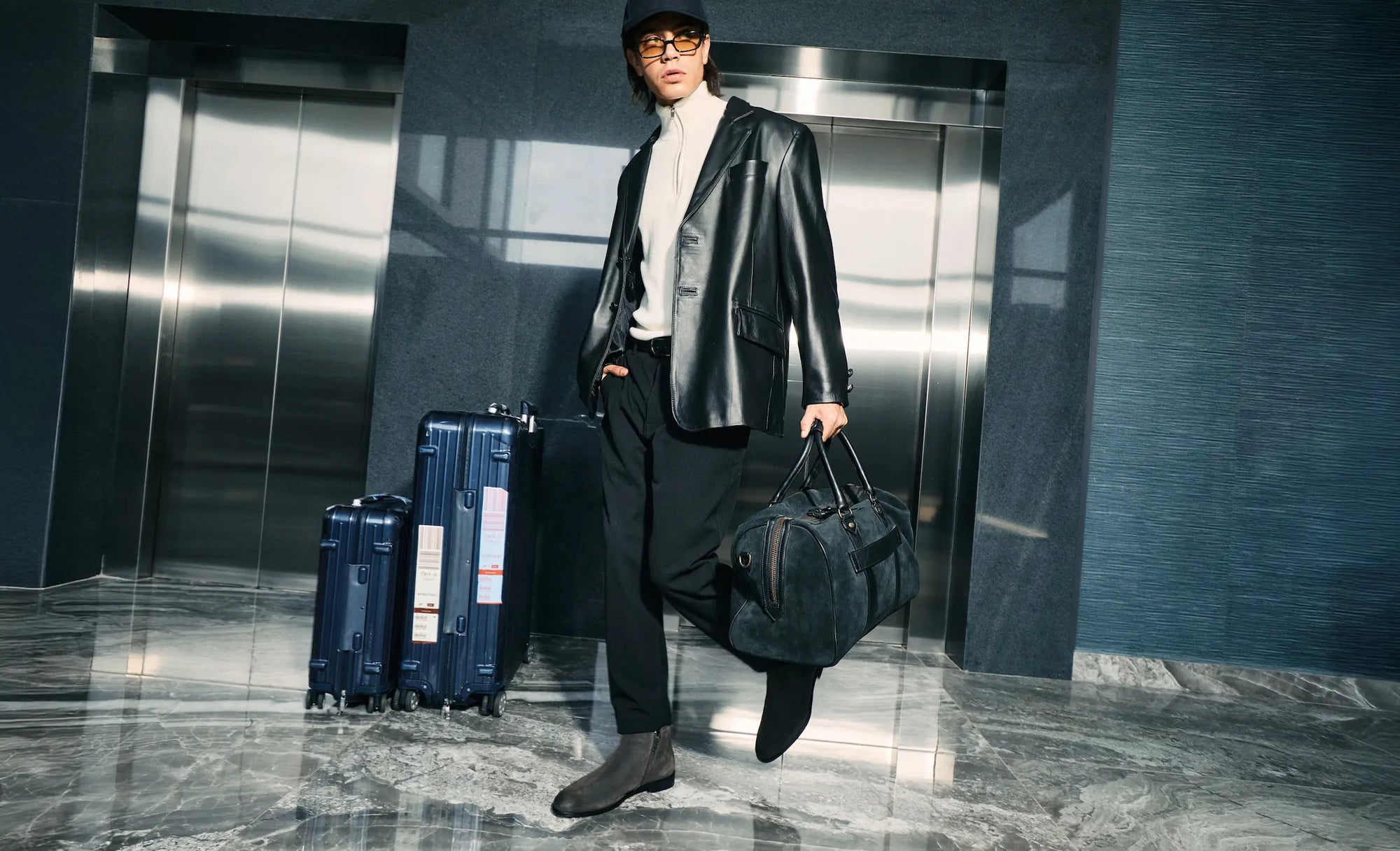 Outfit hombre con saco de piel negro y bolso de viaje Brantano, estilo urbano otoño-invierno.